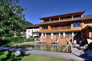 ein Haus mit einem Teich davor in der Unterkunft Antonius Natur Apartment - kinderfreie Unterkunft in Lavant