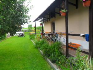 a house with a yard with a table and chairs at Útulná chalupa za potokom Sklené in Sklené