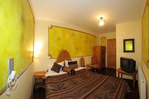 a bedroom with a large bed and a television at Pensiune Citadela Sighisoara in Sighişoara