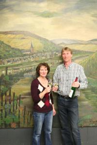 a man and a woman standing in front of a painting at Ferienweingut Hensler in Briedel