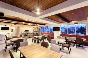 un restaurante con techos de madera, mesas y sillas en San Juan Hotel Boutique Pasto, en Pasto