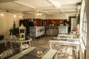 a room with tables and chairs and a kitchen at Hôtel BURLATIS in Sainte-Énimie +18 photos