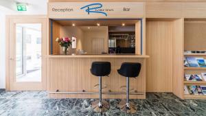 un salón con dos taburetes frente a un mostrador en b&b River Inn, en St. Moritz