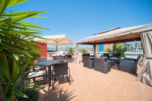 a patio with tables and chairs and an umbrella at Hotel Tiempo in Naples