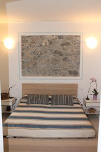 モンテロッソ・アル・マーレにあるマリアンナ クワイエット ルームズの壁に絵画が描かれたベッドルームのベッド1台