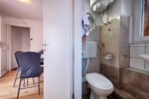 a small bathroom with a toilet and a chair at Apartments Nikola Vidović in Komiža +46 photos