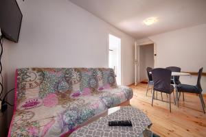a living room with a couch and a table with chairs at Apartments Nikola Vidović in Komiža
