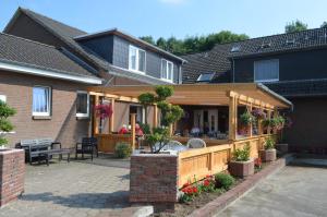 een huis met een houten terras en een patio bij Am Alten Hafen in Neuharlingersiel