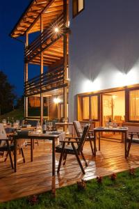 a patio with tables and chairs on a wooden deck at B&B Apartments Burić Plitvice Lakes in Seliste Dreznicko