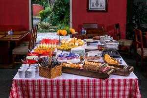 a table with food on a red and white checked table cloth at Pousada Albergo Del Leone in Itaipava