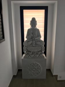 a statue of a buddha in front of a door at Hostal Alisol Boutique San Pedro in Marbella