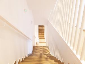 uma escadaria numa casa branca com pisos em madeira em Hostal Alisol Boutique San Pedro em Marbella