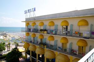 ミザーノ・アドリアーティコにあるSavoia Hotelの黄色のバルコニーとビーチのあるホテル