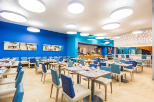 a dining room with blue walls and tables and chairs at Cosmos Pacifico Hotel in Buenaventura +65 photos