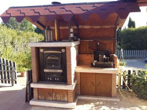 a outdoor kitchen with an outdoor oven with a roof at B&B Villa Roberta in Viterbo