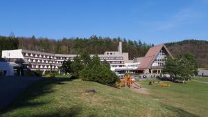 a large building with a playground in front of it at Všemina Apartman in Lužkovice