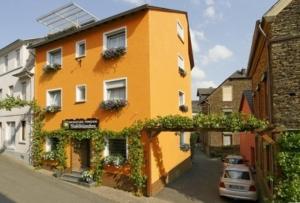 an orange building with a car parked in front of it at Weinstube Pension Moselblümchen in Zeltingen-Rachtig