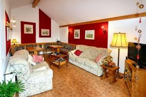 a living room with two couches and a television at Weinstube Pension Moselblümchen in Zeltingen-Rachtig