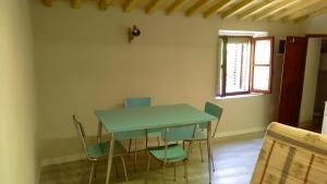 a dining room with a green table and chairs at Casa Maria Teresa in San Donato in Poggio