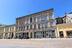 a large brick building on a city street at Liela Guest Apartament in Liepāja