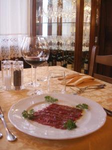 a plate of food on a table with wine glasses at Albergo Ciori in Asiago