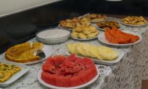 a table topped with plates of different types of food at Pousada O Ninho in Salvador