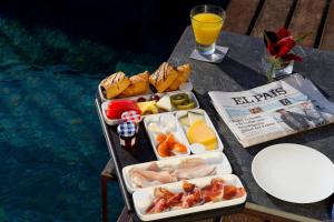 a tray of food on a table next to a pool at Hotel Boutique Ses Pitreras in San Antonio Bay