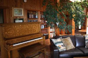 a living room with a piano and a leather couch at Summers House in Sonoma
