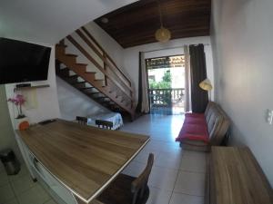 a living room with a wooden table and a staircase at Apartamentos La Piazzetta Duplex in Pipa