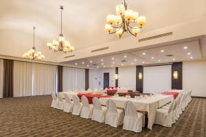 um salão de banquetes com mesas brancas e cadeiras brancas em Casa Grande Delicias em Delicias
