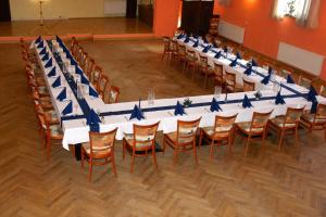 a long table with blue bows on it in a room at Bluhm's Hotel & Restaurant am Markt in Kyritz