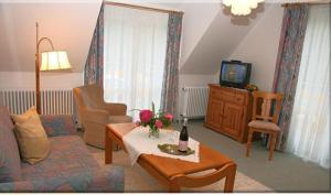 ein Wohnzimmer mit einem Sofa und einem TV in der Unterkunft Landhaus Weilertal in Badenweiler