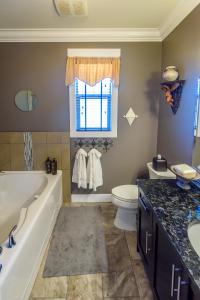 a bathroom with a tub and a toilet and a sink at Brookside Inn Boutique Hotel in Abbotsford