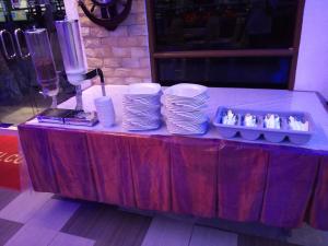 a table with a bunch of dishes and plates on it at Al Safina Kijal Beach Resort in Kijal