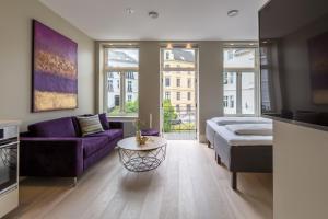 a living room with a purple couch and a table at 2 Døtre Apartments by Hotel Park in Bergen
