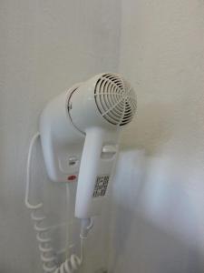 a white hair dryer hanging on a wall at Pousada Bruma in Caraíva