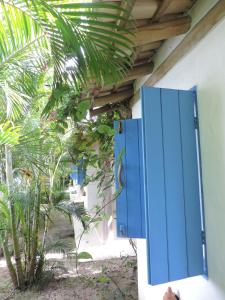 una puerta azul en el lateral de un edificio en Pousada Bruma, en Caraíva