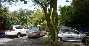 a group of cars parked in a parking lot at ApartHotel Villa Pacande & Rooms in Alajuela