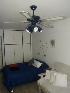 1 dormitorio con 1 cama y ventilador de techo en Estudio en Edificio Alnes en Mar del Plata