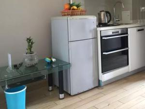 uma cozinha com um frigorífico branco e uma mesa em He&Her Youth Hostel em Hangzhou