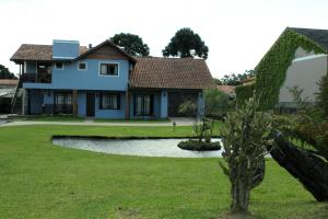 een huis met een vijver in de tuin bij Residencial Aconchego do Lago in Gramado