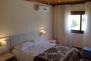 a bedroom with a large bed and a window at Residencial Aconchego do Lago in Gramado