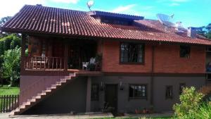 a brick house with a balcony and a staircase at Casarão Villa maggi in Canela