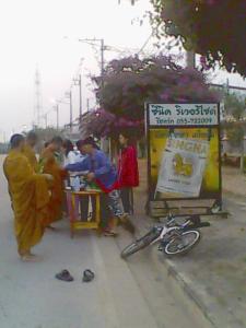 eine Gruppe von Menschen, die um einen Tisch mit einem Fahrrad stehen in der Unterkunft Scenic Riverside Resort in Kamphaeng Phet
