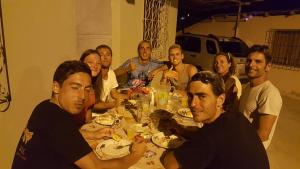 un grupo de personas sentadas alrededor de una mesa comiendo en Hostal Centro Turístico San Mateo, en Manta