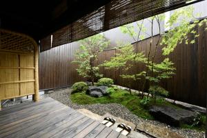 a japanese garden with a wooden walkway at Kuraya Nanseicho in Kyoto