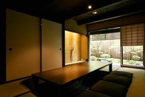 a living room with a table and a window at Kuraya Nanseicho in Kyoto