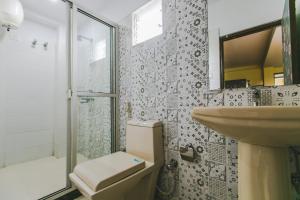 a bathroom with a sink and a toilet and a shower at Hotel Platinum in Kolkata +22 photos
