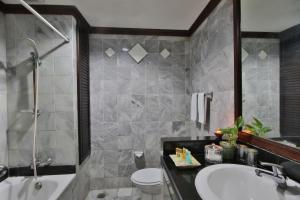 a bathroom with a sink and a tub and a toilet at The Jayakarta Bali Beach Resort in Legian