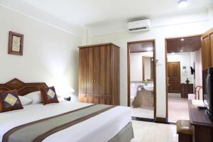 a bedroom with a large bed and a television at The Jayakarta Bali Beach Resort in Legian
